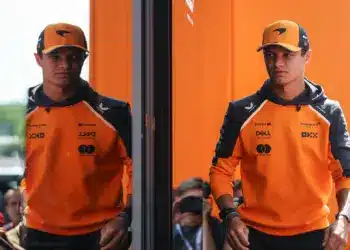 Lando Norris, tükröződve a McLaren vendéglátóegységének üvegében