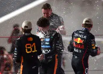 Oscar Piastri, Lando Norris és Max Verstappen pezsgőzve ünnepel a dobogón, F1 2025 Abu Dhabi