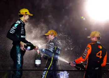 Lando Norris, Max Verstappen, George Russell pezsgőt locsolnak a dobogón Abu Dhabiban