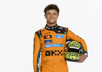 Lando Norris 2026 stúdiófotó, overálaban, sisakkal a kezében