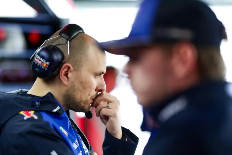 Gianpiero Lambiase, gondolkodó pózban. Az előtérben homályosam Max Verstappen